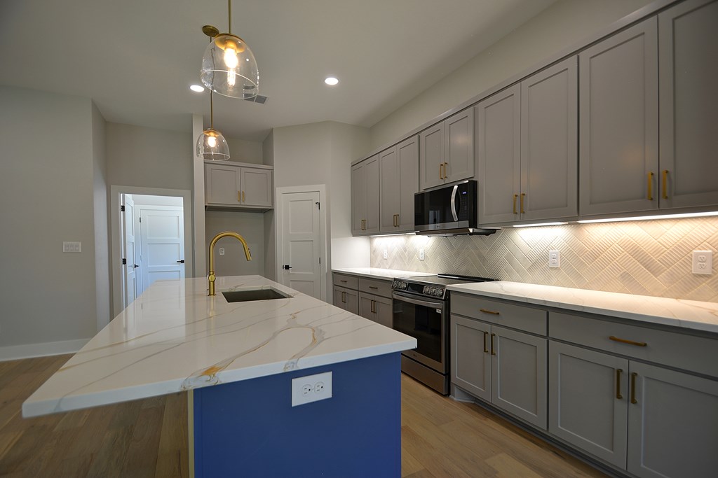 513 Conner Court Kerrville, TX 78028 - Photo 12 of 54 a kitchen with kitchen island granite countertop a sink stainless steel appliances and white cabinets