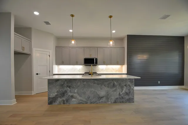 a view of a large kitchen with a sink a large window and stainless steel appliances