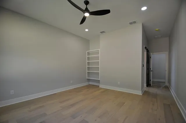 an empty room with closet and a ceiling fan
