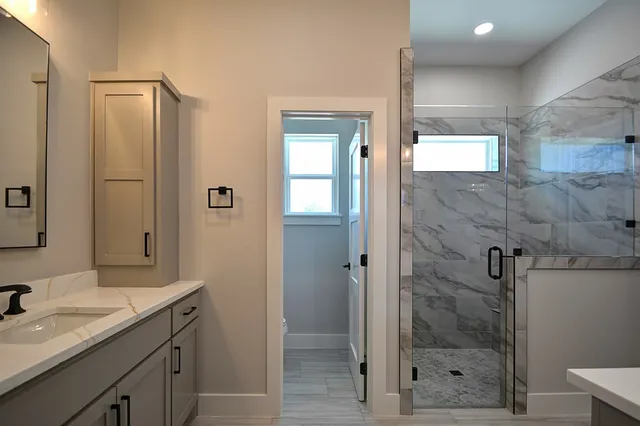 a bathroom with a shower sink and mirror