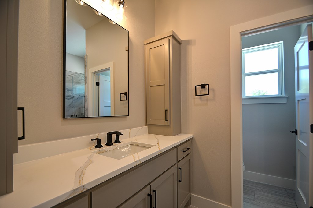 513 Conner Court Kerrville, TX 78028 - Photo 24 of 54 a bathroom with a granite countertop sink and a mirror