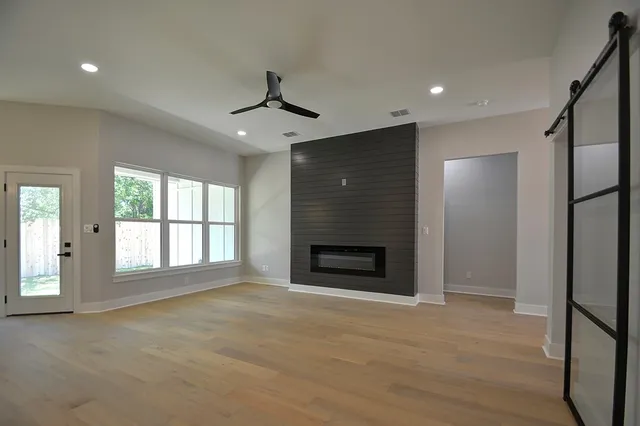 a view of an empty room with a fireplace and a window