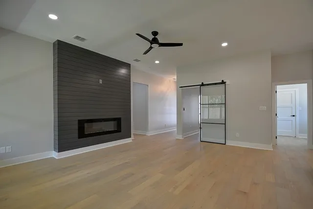 an empty room with windows and fireplace