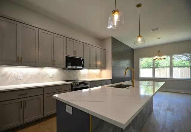 a kitchen with stainless steel appliances granite countertop a sink a stove and a microwave