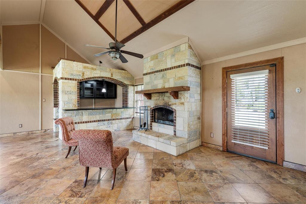 3433 West Tours Road West, TX 76691 - Photo 21 of 40 Living area with healthy amount of natural light, a stone fireplace, lofted ceiling, and ceiling fan