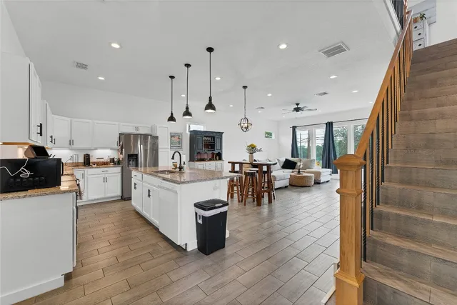a large white kitchen with lots of counter space and stainless steel appliances
