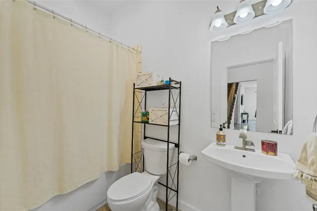 a bathroom with a sink a toilet and mirror