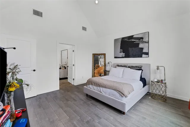 a bedroom with a bed a flat screen tv and dresser