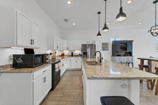 a kitchen with stainless steel appliances granite countertop a sink a stove and cabinets