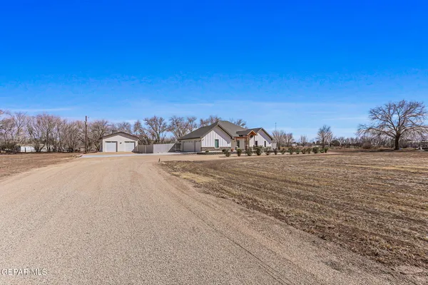 a view of an empty room with a fireplace and a ceiling fan