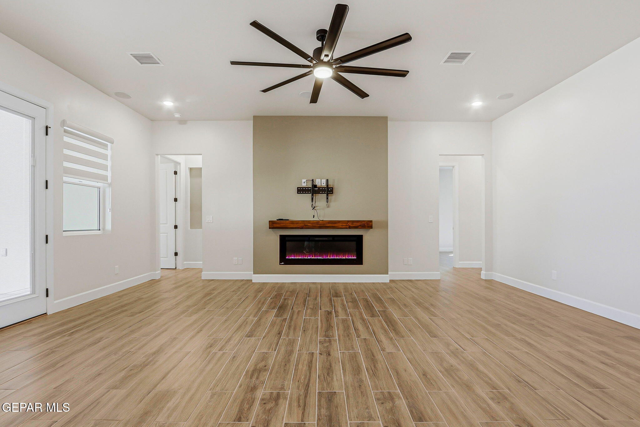 12329 Sugden Road Clint, TX 79836 - Photo 29 of 101 a view of an empty room with a fireplace and a ceiling fan