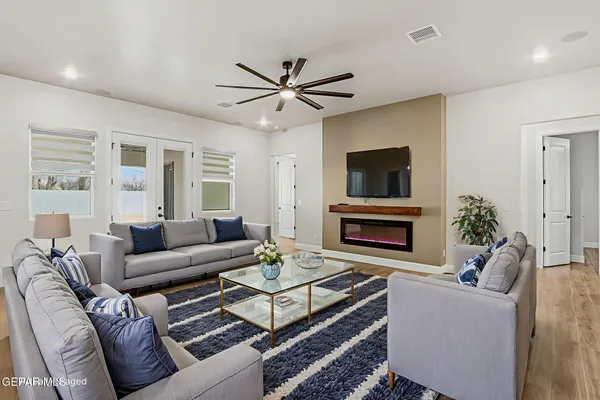 an empty room with wooden floor and a ceiling fan