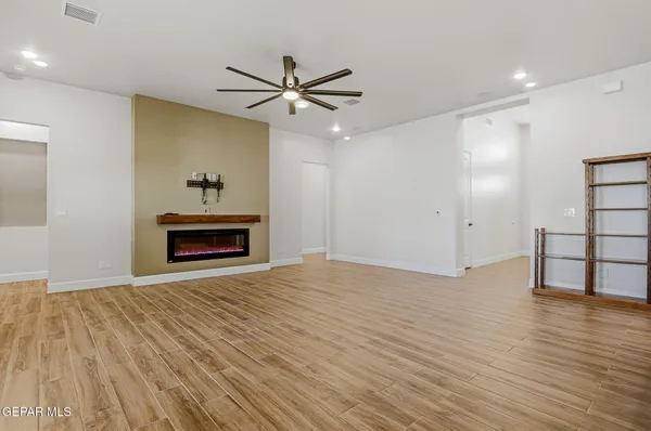 a view of room with hardwood floor and ceiling fan