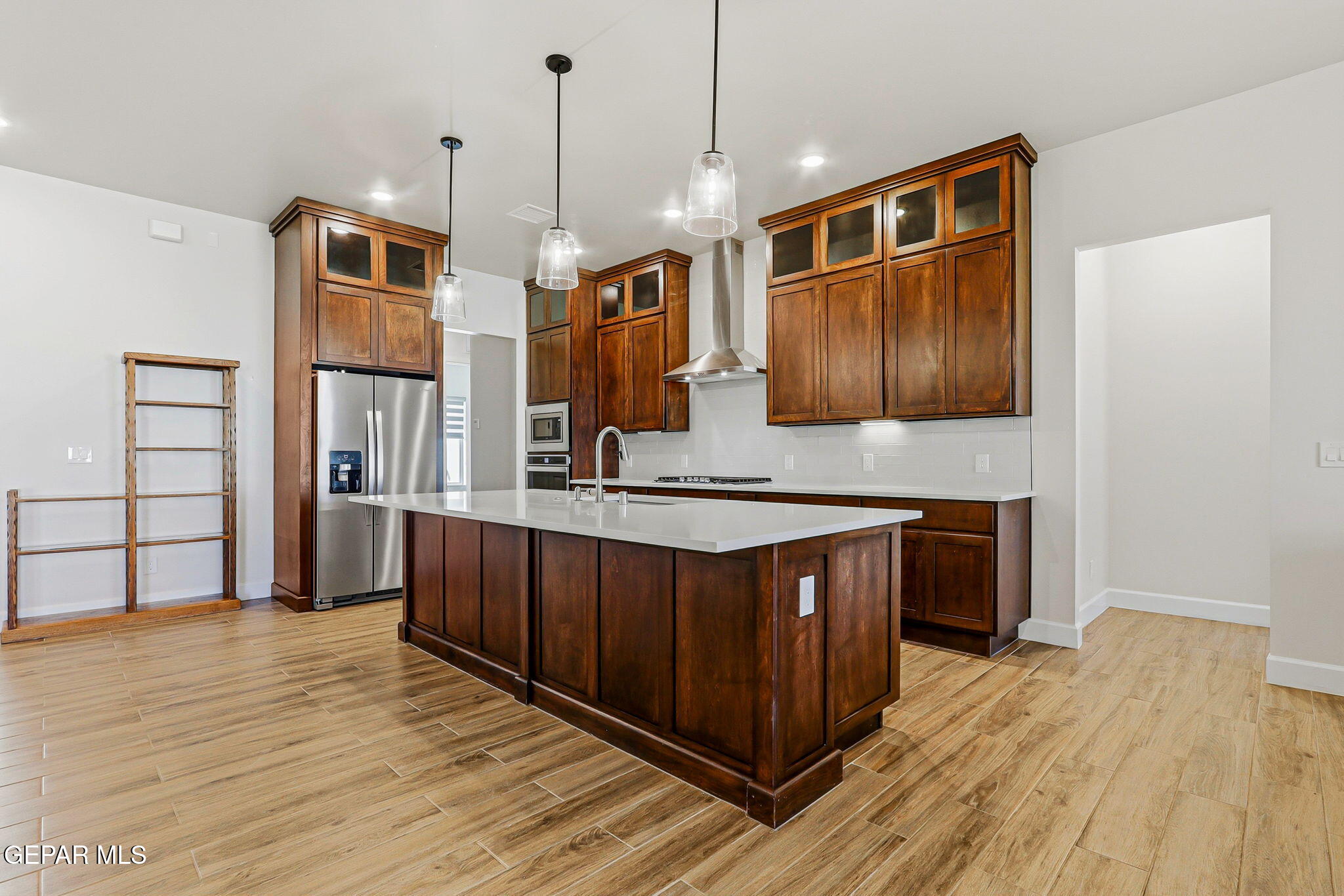 12329 Sugden Road Clint, TX 79836 - Photo 34 of 101 a kitchen with stainless steel appliances granite countertop a sink a stove and a wooden floors