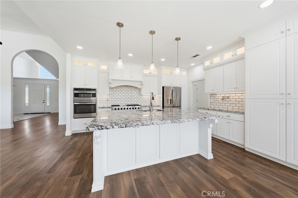 13925 Noble Way Red Bluff, CA 96080 - Photo 11 of 57 a large kitchen with stainless steel appliances kitchen island a large counter space and wooden floor