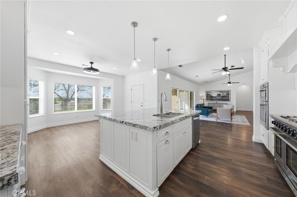 13925 Noble Way Red Bluff, CA 96080 - Photo 15 of 57 a large kitchen with stainless steel appliances granite countertop a stove and a wooden floors