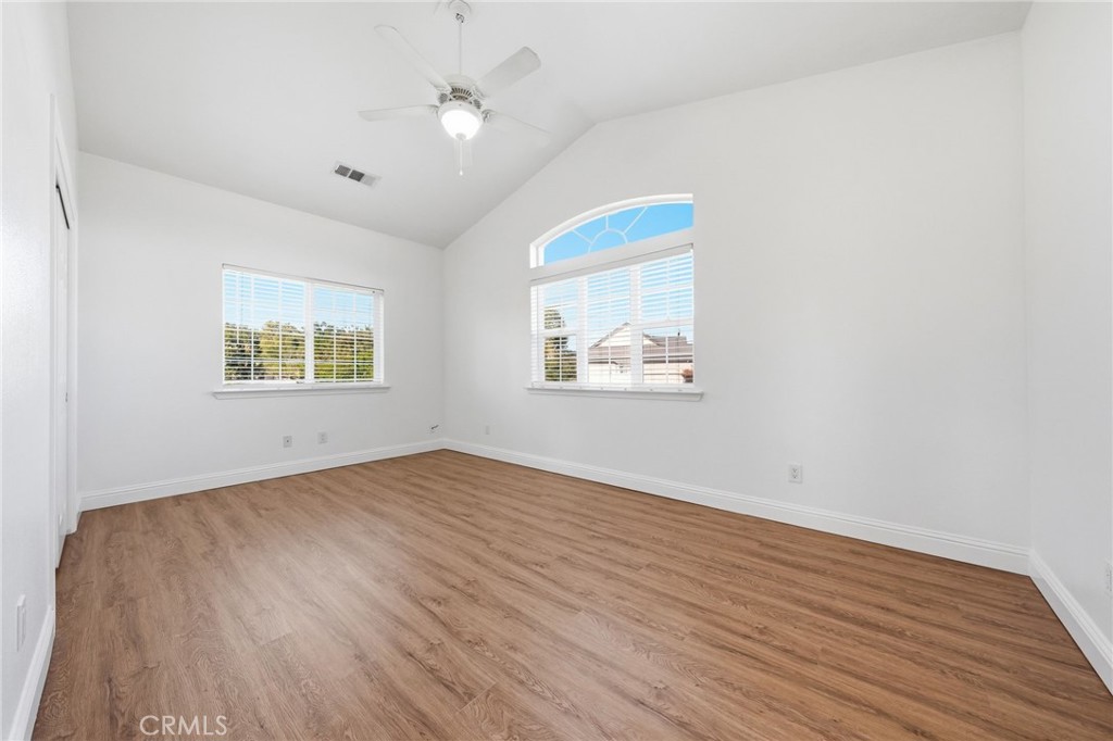 13925 Noble Way Red Bluff, CA 96080 - Photo 25 of 57 an empty room with wooden floor ceiling fan and windows