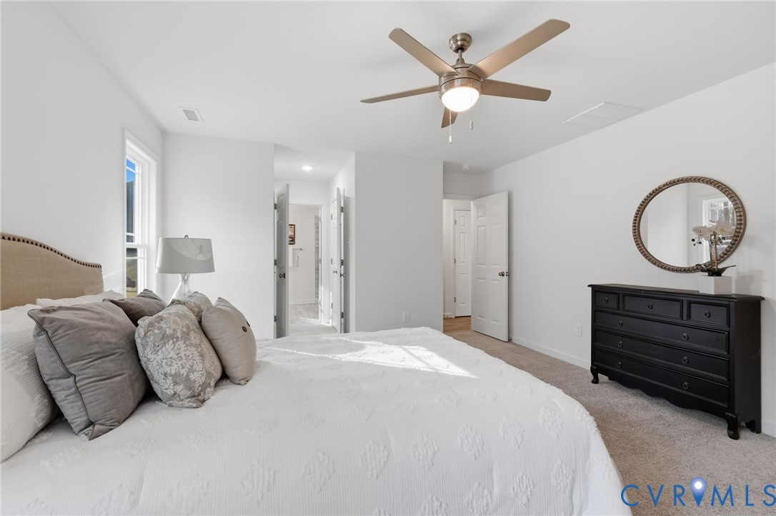 2214 Walnut Tree Boulevard Powhatan, VA 23139 - Photo 17 of 30 a bedroom with a bed a mirror and a chandelier