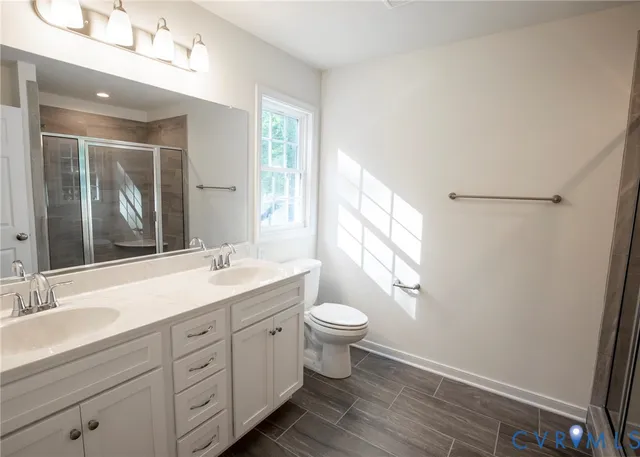 a bathroom with a double vanity sink toilet mirror and window