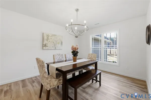 a living room with furniture kitchen view and a chandelier