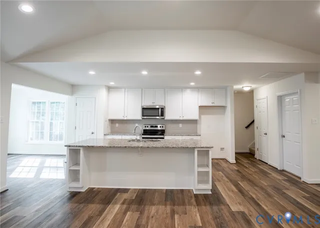a kitchen with stainless steel appliances granite countertop a stove a sink and a refrigerator