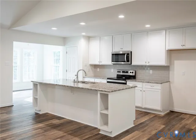 a kitchen with granite countertop a sink and steel appliances