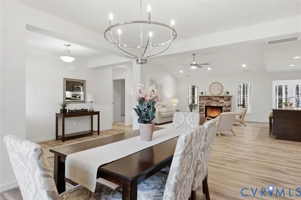 a living room with furniture a chandelier and a dining table