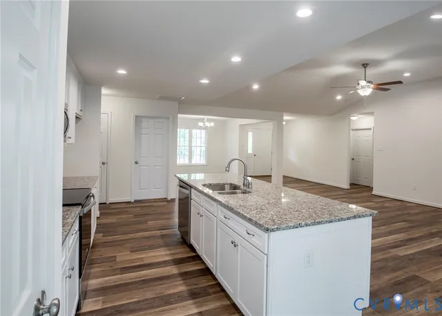 a kitchen with stainless steel appliances granite countertop a sink stove and refrigerator