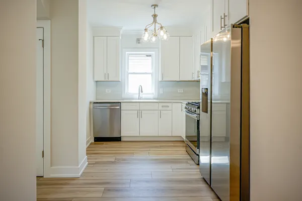 a kitchen with stainless steel appliances a refrigerator sink and cabinets