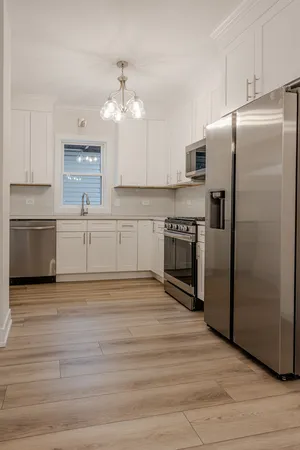 a kitchen with stainless steel appliances granite countertop a refrigerator and a stove top oven