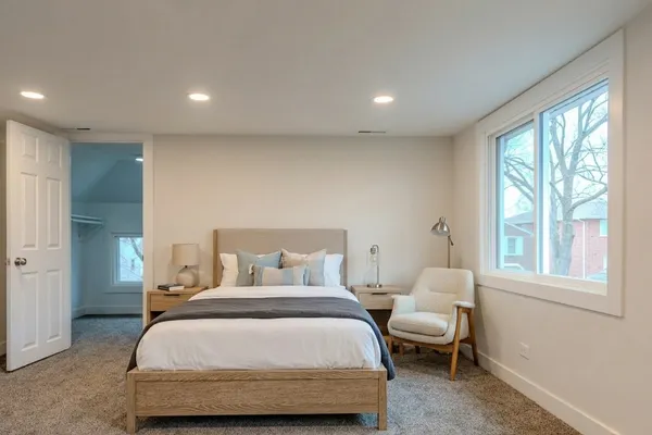 a bedroom with a bed and a large window