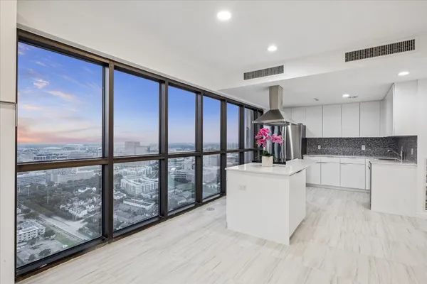 a living room with stainless steel appliances granite countertop a stove and a view of living room