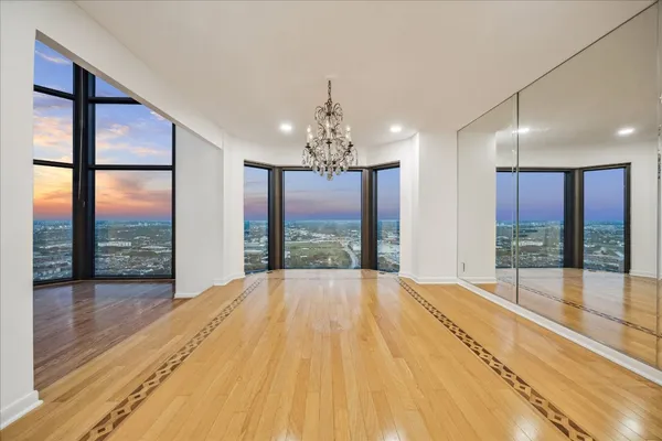a spacious bedroom with a large window and a chandelier