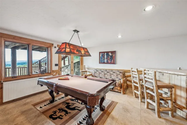 a dining room with wooden floor and large windows