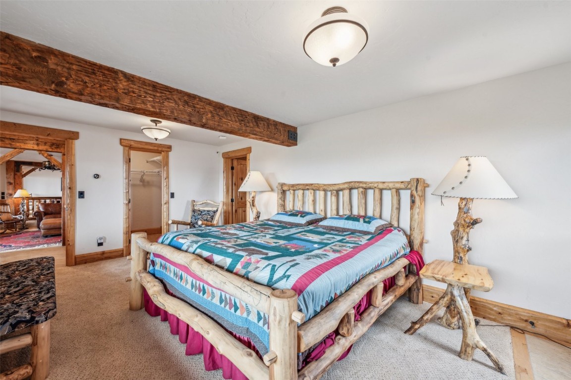 733 Spring Creek Ranch Road Silverthorne, CO 80498 - Photo 18 of 37 a bed room with a bed and a chandelier