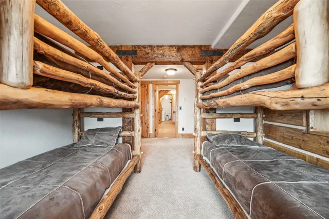 a spacious bedroom with a bed a chandelier and balcony