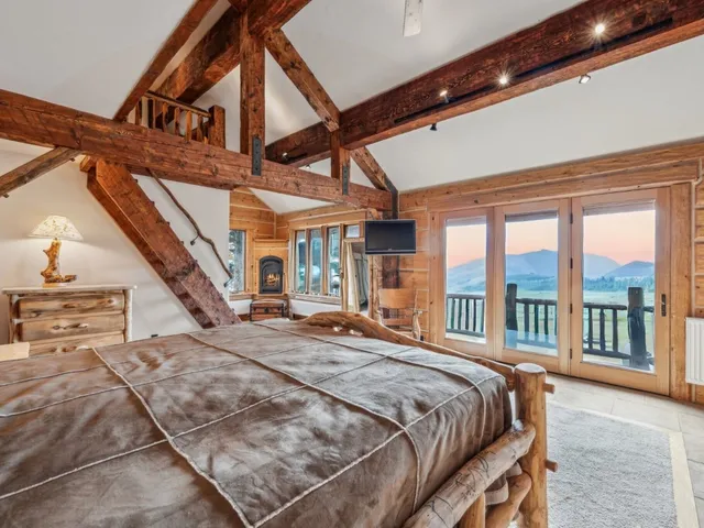 a bed sitting in a bedroom next to a large window