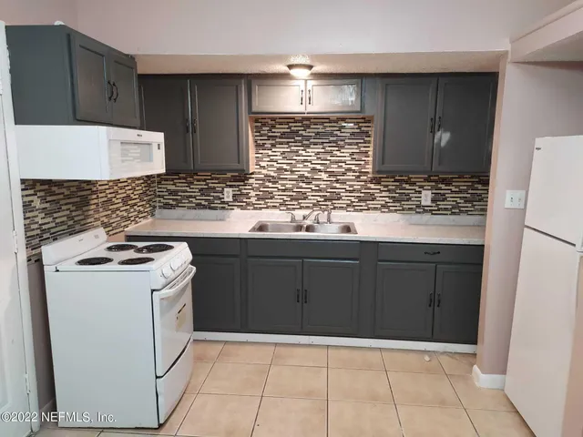 a kitchen with a stove top oven and cabinets