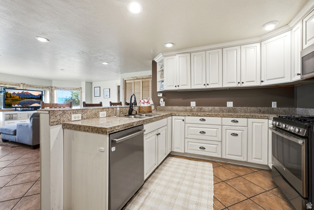 335 Bern Way Midway, UT 84049 - Photo 65 of 88 Kitchen featuring white cabinetry, stone countertops, stainless steel appliances, and tile flooring