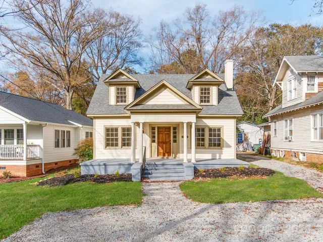 a front view of a house with a garden and trees