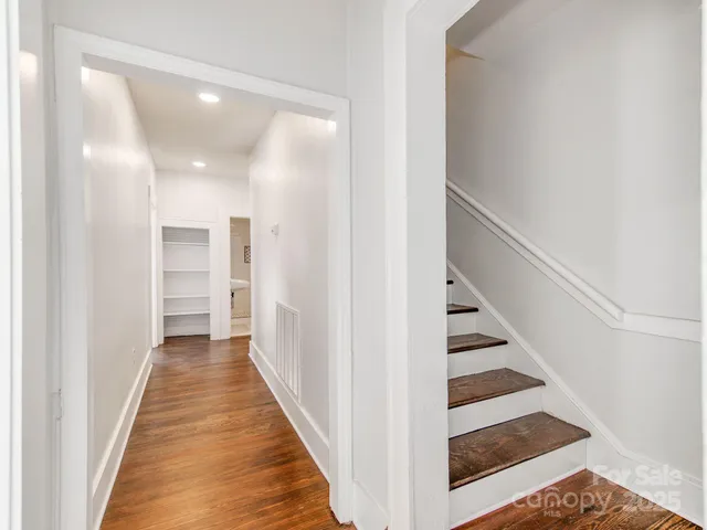 a view of a hallway with wooden floor and entryway