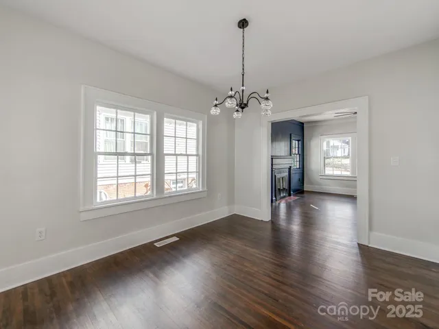 a view of empty room with window and wooden floor
