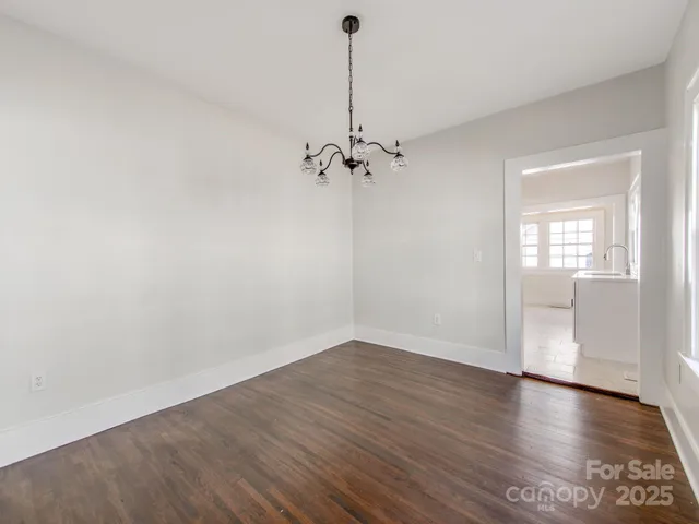 a view of a room with wooden floor and a ceiling fan