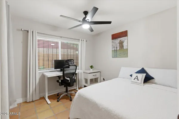 a spacious bedroom with a bed and a dresser