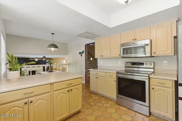a patio with a table and chairs and potted plants