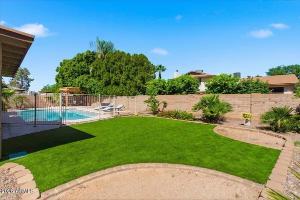 a view of a swimming pool with a patio and a yard