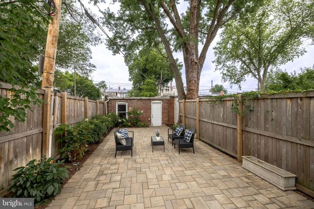 a view of backyard with outdoor seating a patio and plants