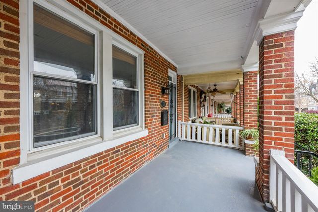 a front view of a house with garden and trees