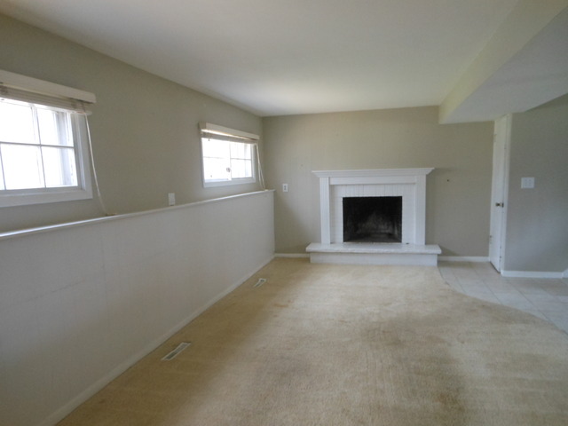 111 Perth Road Cary, IL 60013 - Photo 2 of 6 an empty room with a fireplace and windows