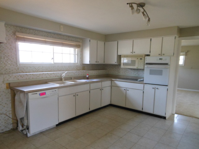 111 Perth Road Cary, IL 60013 - Photo 3 of 6 a kitchen with granite countertop white cabinets and white appliances